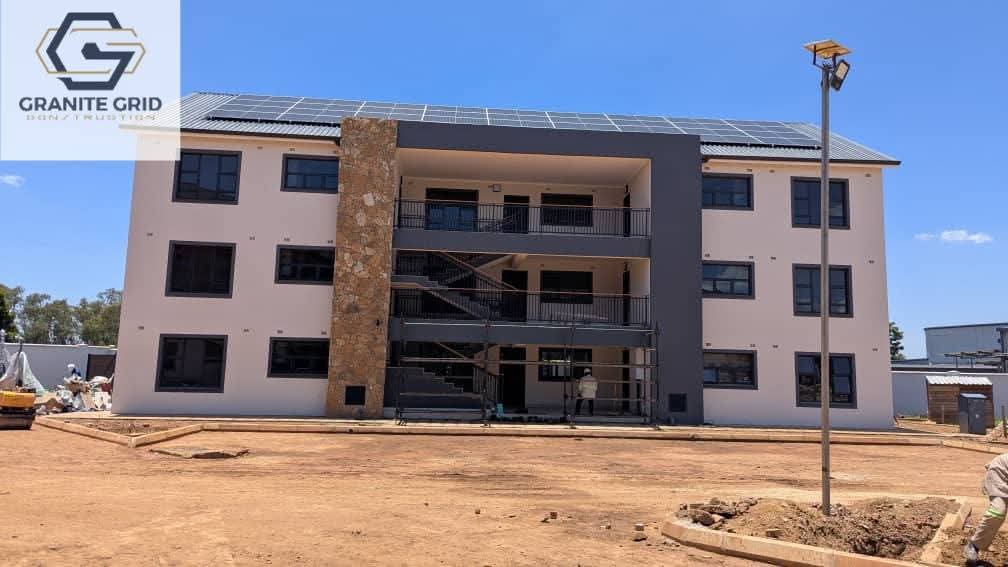Modern multi-storey building with solar panels by Granite Grid Construction